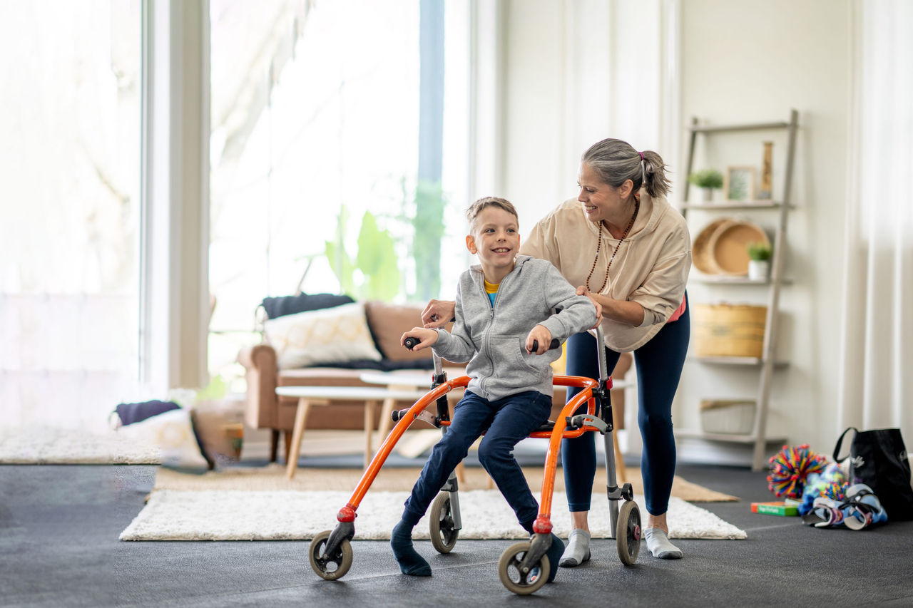 Child with walker assist and caregiver