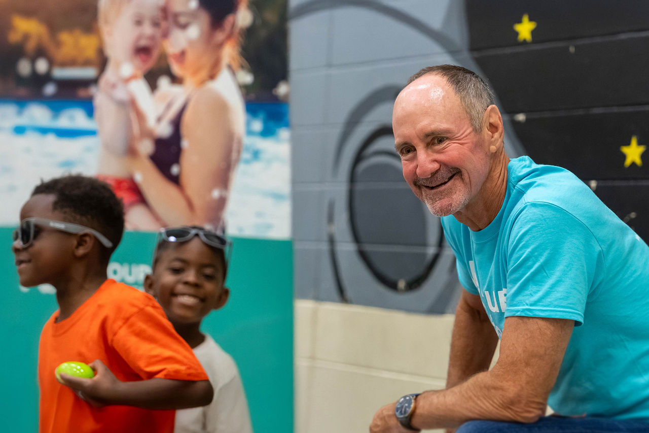 Dr Moss kneeling and smiling at a volunteer event