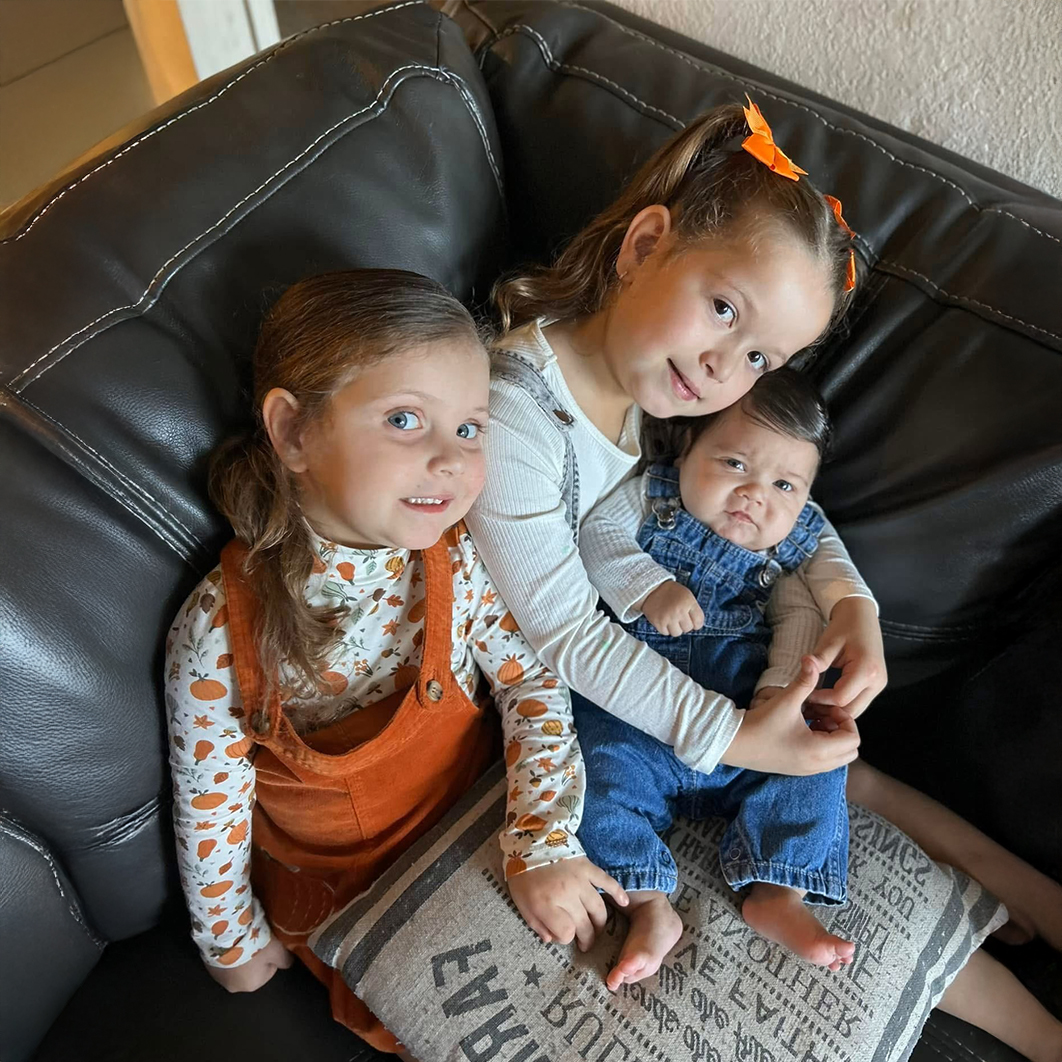 3 children sitting in a comfy chair for Zoe and Brooklyn's story