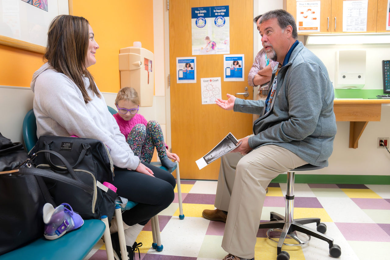 Doctor discussing gait lab with mother and daughter