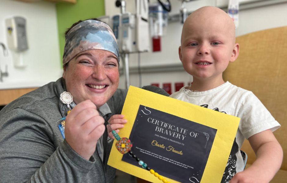 Charlie, a lymphoma patient, holding a certificate of bravery.