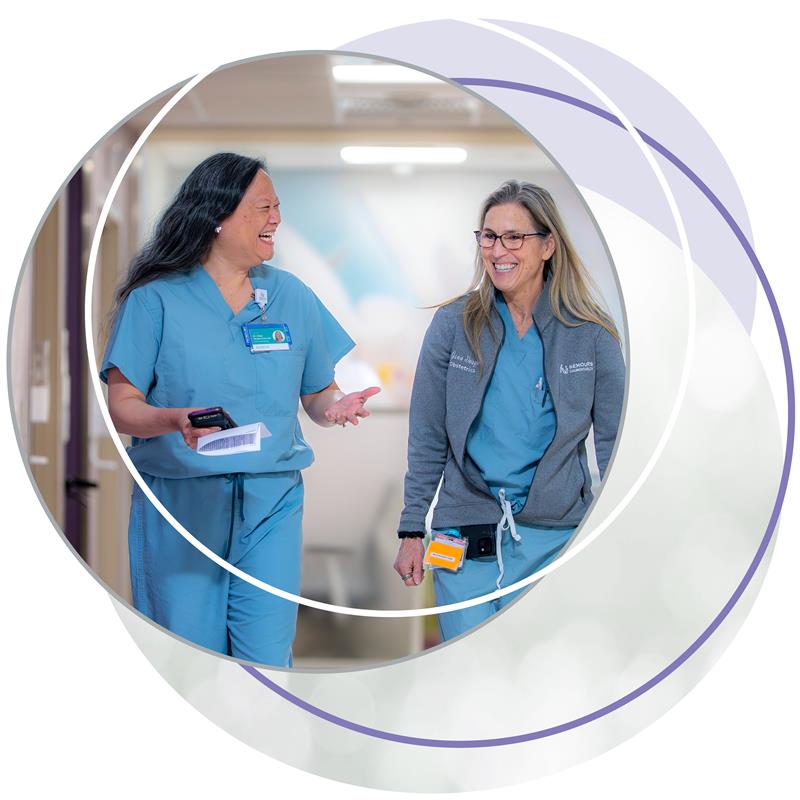 Two Healthcare Professionals Walking in Hospital Corridor