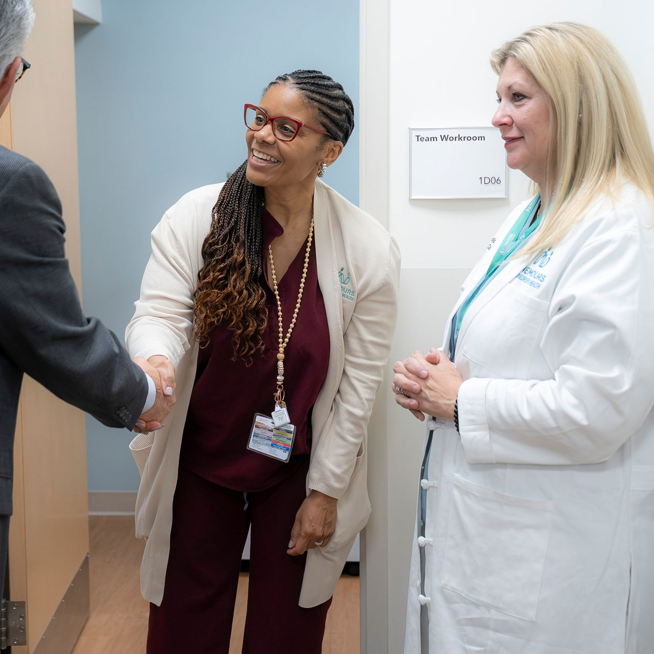 Medical professionals greeting in hospital workroom